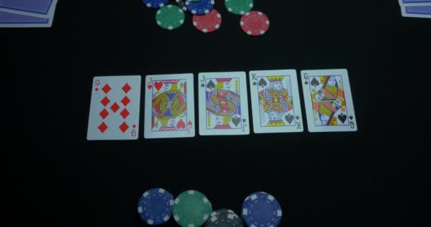 Detail eines Royal Flush auf schwarzem Hintergrund. Royal Flush of Pik im Pokerspiel auf schwarzem Hintergrund. Spieler sammelte den Royal Flush auf einem grünen Pokertisch gegen Schwarz. — Stockvideo