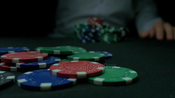 Ağır çekimde bir Poker fişleri atma adam close-Up. Siyah arka plan üzerine kumar cips atma el close-up. Poker oyuncusu belirteçleri oyun masa üstüne atma onun hisselerini artan. — Stok video