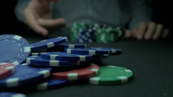 Close-Up of Man Lanzar un Poker Chips en cámara lenta. Primer plano de la mano con el lanzamiento de fichas de juego sobre fondo negro. Jugador de póquer aumentando sus apuestas lanzando fichas a la mesa de juego . — Vídeos de Stock
