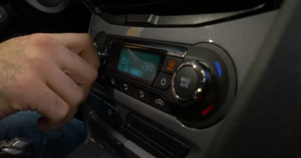 Primer plano de la mano ajustando el botón de aire acondicionado en el coche. Hombre utilizando el sistema de aire acondicionado del automóvil — Vídeo de stock