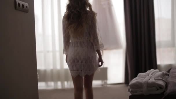結婚式の前に彼女の下着で美しい女性。女の子が下着姿でウェディング ドレスに行く — ストック動画