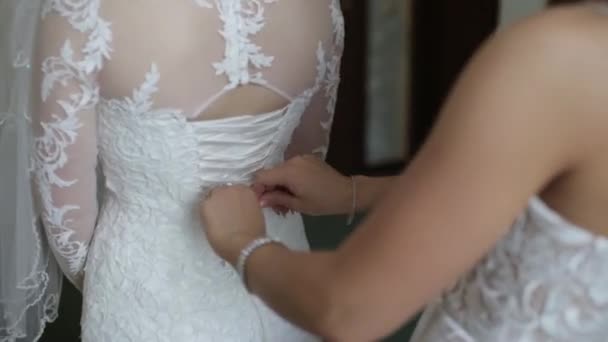 Ranní nevěsta. Družička pomáhá nevěstě šněrování se její šaty. Kamarádky pomoci nevěsta k připevnění šaty — Stock video