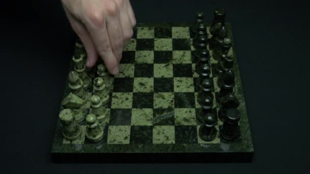 男人首先会移动在一盘棋。竞争的开始。第一步。手象棋和国际象棋棋盘与棋子 — 图库视频影像