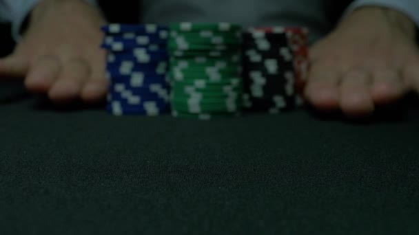 Poker chips and hands above it on green table. blackjack in a casino, a man makes a bet, and puts a chip. Stack of poker chips and two hands on green table. — Stock Video