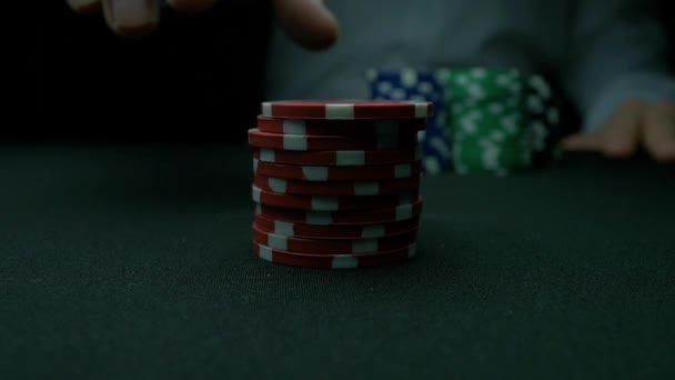 포커 칩 그리고 녹색 테이블에 위에 손을. 남자는 카지노에서 블랙 잭 내기, 고 칩을 넣습니다. 포커 칩 스택과 녹색 테이블에 두 손을. — 비디오