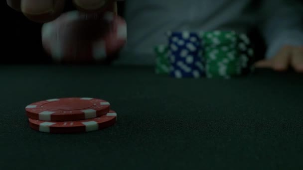 Pokermarker och händerna ovanför på gröna bordet. Blackjack i ett kasino, en man gör en satsning, och sätter ett chip. Stack av pokermarker och två händer på gröna bordet. — Stockvideo