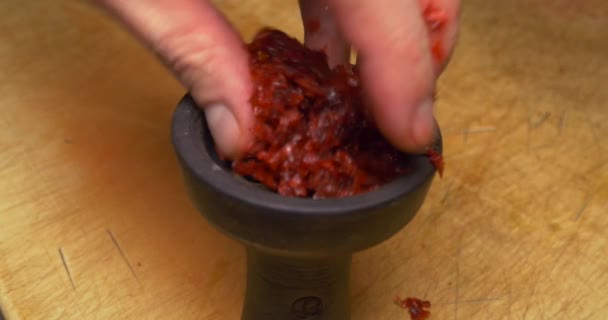 Mans hands at work on making a shisha bowl close up. man puts tobacco in the hookah bowl. close-up. Cooking bowl for hookah. Hookah flavor tobacco with hookah bowl — Stock Video