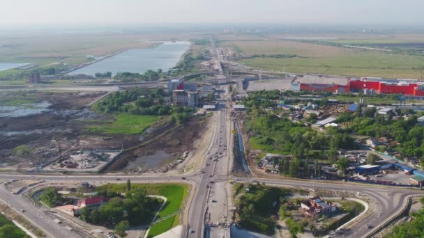 Luchtfoto Stadszicht met kruispunten en wegen, huizen, gebouwen, parken en parkeerterreinen, bruggen. Stedelijk landschap. Copter geschoten. Panoramisch. Uitzicht vanuit de hemel op de stad in zomerdag — Stockvideo