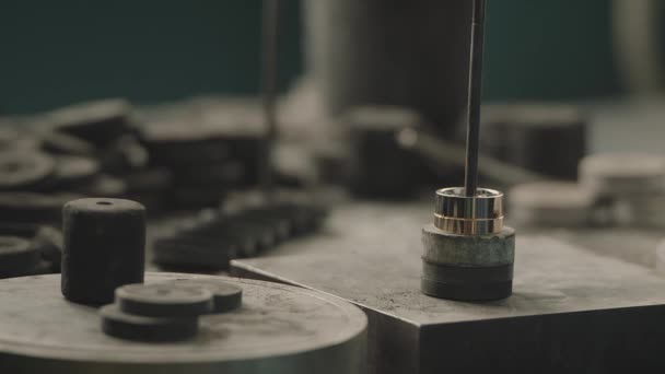Виробництво кілець. Ювелір працює з восковою моделлю кільця в його майстерні. Виготовлення ювелірних виробів. Детальний знімок з низькою глибиною різкості. Ювелір виготовляє ювелірні вироби ручної роботи на вінтажному верстаті. Виробництво — стокове відео