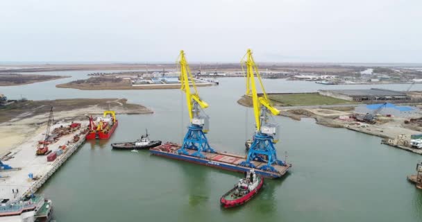 Bogsering kranar för behållare. Stora containerfartyg drog av bogserbåtar. Top-down Flygfoto. Cargo containerfrakt medföljer arbetar crane bridge i varvet i skymningen för logistisk Import Export — Stockvideo