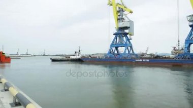 Vinçler için konteyner timelapse çekme. Konteyner gemisi limanda yükleme tamamlandıktan sonra kalkış için yardımcı römorkör.