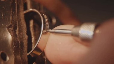 Kuyumcu bir değerli taş kuruyor. El sanatları takı yapımı. Tamir halka. Elmas yüzüğü koyarak. Makro video. İle profesyonel araçları yapımı craft mücevher. Elmas belirli bir konuma geçirme