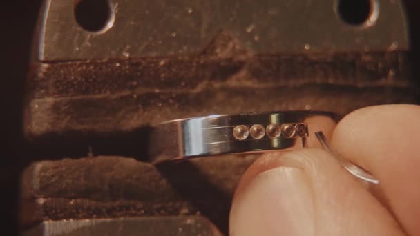 Juveleraren sätter en ädelsten. Hantverk smycken att göra. Ring reparera. Att sätta diamanten på ringen. Makro video. Hantverk smycken att göra med professionella verktyg. Att sätta diamanten på den — Stockvideo