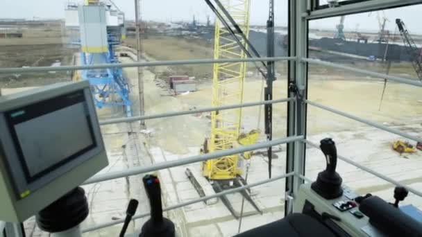 Cabine pour contrôler la grue. Vue depuis le poste de travail du grutier. Un grutier déplace un conteneur maritime. cabine — Video