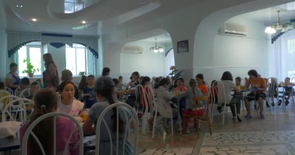 Moscú, Rusia - 10 de junio de 2017, Los niños cenan en el comedor. Niños sentados en la mesa de la cafetería mientras almorzan — Vídeos de Stock