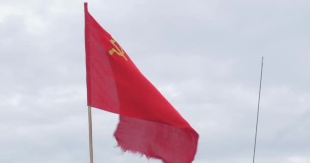 A bandeira da URSS que se desenvolve no vento em um mastro de bandeira em um dia ventoso. Bandeira da União Soviética contra o céu — Vídeo de Stock