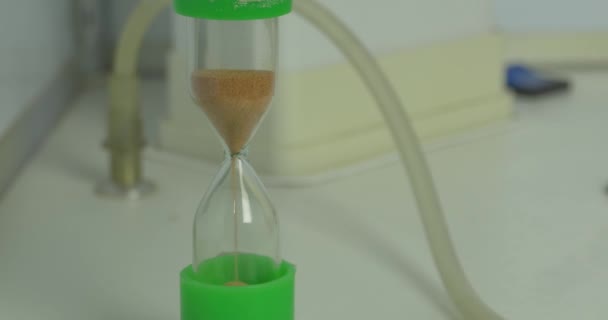 La sabbia scorre attraverso le lampadine di una clessidra misurando il tempo che passa in un conto alla rovescia fino a una scadenza. clessidra — Video Stock
