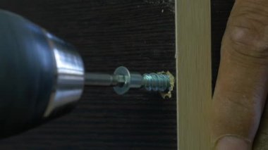 Bir elektrikli el matkabı bir Pano bir vida sürücü kullanan adam. Ortamda bulunan toz tanecikleri Parlatıcı havadaki toz. Vida sıkma, yavaş hareket