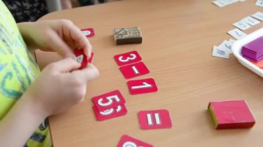 Matematiksel bir örnek. Çocuk bir kağıt rakam tutar. İlkokul matematik problem çözme.