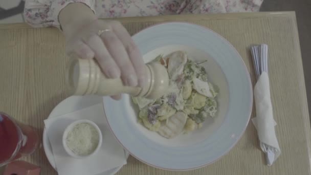 Femme à la maison ajoutant du sel au repas. Salière, sel, nourriture. La plaque de nourriture, la vue du haut — Video