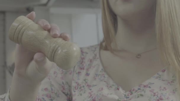 Het toevoegen van zout. Backlight te zout uit zout shaker. Close-up, jonge vrouw augurken eten, langzame motie — Stockvideo
