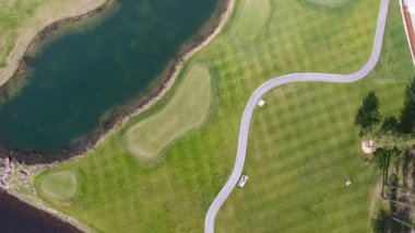 Güneşli bir golf sahası, gölet ve yeşil çimen, mükemmel bir Golf sopasıyla görüntülemek gökten