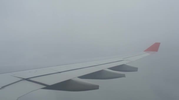 Wolken en lucht zoals gezien door het venster van een vliegtuig. Vleugel van een vliegtuig vliegen boven de wolken. mensen kijkt naar de lucht vanuit het raam van het vliegtuig, met behulp van airtransport te reizen. bewolkt weer — Stockvideo