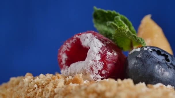Căpșuni tăiate și afine pe tort. Scânteia de aprindere pe un tort pentru copii cu căpșuni și afine. tort și decor proaspăt boabe — Videoclip de stoc