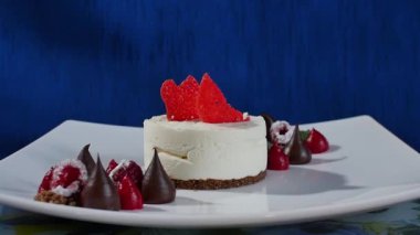 Kek beze krema ve ahududu. Taze Ahududu ve koyu mavi zemin üzerine yaban mersini ile Meringues Pavlova kek. Büyük beze zephyr plaka üzerinde
