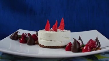 Kek beze krema ve ahududu. Taze Ahududu ve koyu mavi zemin üzerine yaban mersini ile Meringues Pavlova kek. Büyük beze zephyr plaka üzerinde