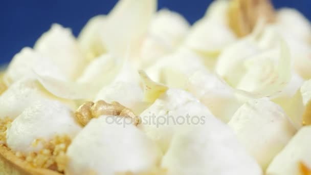 Un grand gâteau meringue à l'air rond torte sur un plat en porcelaine bleue sur un fond bleu foncé. Près du gâteau à la meringue. Morsure de tarte au citron prête à servir 