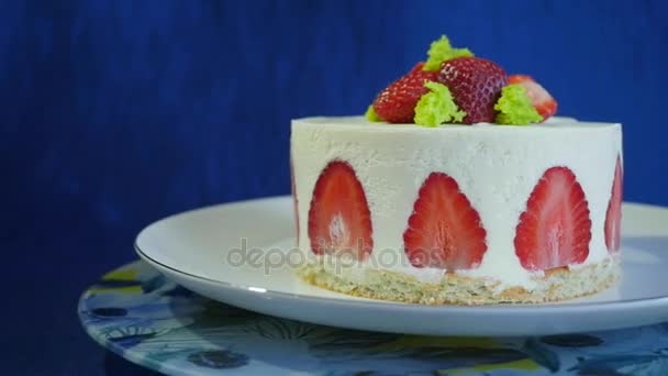 Aardbei cake op een donker blauwe achtergrond. Mooie cake met aardbeien en room Slow motion — Stockvideo