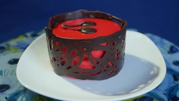 Beautiful cake with red glossy glaze. Red cake on a dark blue background. Close up. Slow motion — Stock Video