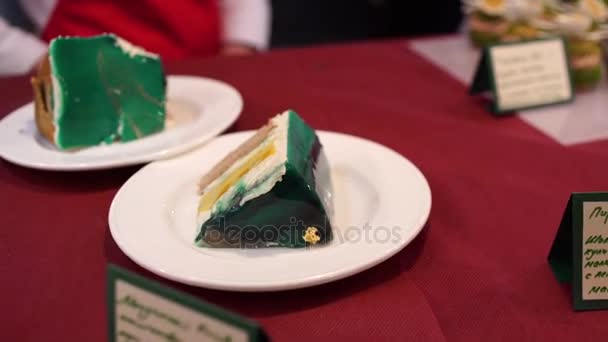 Delicioso bolo de chocolate em placa branca sobre fundo de mesa de madeira, close-up. Bolo de chocolate saboroso com bagas na mesa — Vídeo de Stock