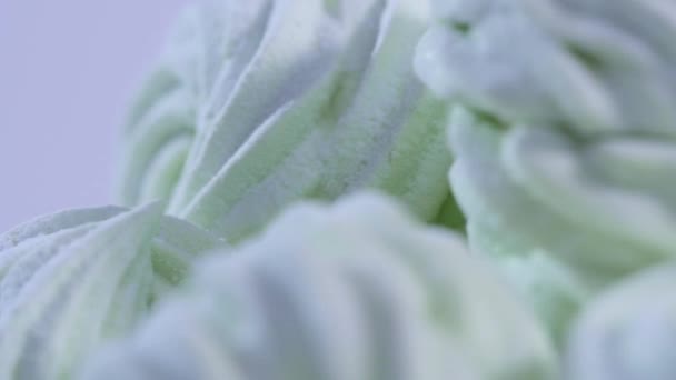 Guimauve blanche moelleuse dans un bol rond bleu sur une vieille table en bois avec espace de copie à proximité. Gros plan de nombreuses guimauves rondes sucrées dodues sur plaque blanche. Fond à pois. Vue latérale 