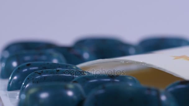 Blue candy around the team logo close up. Candy on the table. Blue and black lollipops. Slow motion — Stock Video