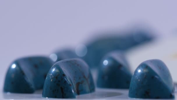 Bonbons bleus autour du logo de l'équipe gros plan. Des bonbons sur la table. Sucettes bleues et noires. Mouvement lent 