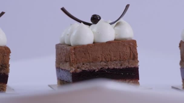 Un pastel de chocolate en un plato blanco con crema batida. Postre mousse de chocolate con crema batida de cerca — Vídeos de Stock