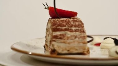 Ahşap masa üzerinde üstten görünüm çilekli cheesecake in. Çilekli çikolatalı kek parçası süslemeleri üstte. Bir parça taze çilek üstte ve çilek ile nemli cheesecake