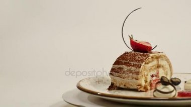 Ahşap masa üzerinde üstten görünüm çilekli cheesecake in. Çilekli çikolatalı kek parçası süslemeleri üstte. Bir parça taze çilek üstte ve çilek ile nemli cheesecake