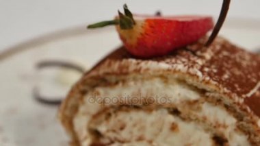 Çilekli kek. Çilek kısa pasta. Kalp üzerinde kremalı çikolatalı kek parçası plaka, çilek şeklinde kalp ile tepesinde şeklinde. Krep pasta çilekli tepesi ile