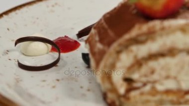 Çilekli kek. Çilek kısa pasta. Kalp üzerinde kremalı çikolatalı kek parçası plaka, çilek şeklinde kalp ile tepesinde şeklinde. Krep pasta çilekli tepesi ile