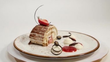 Çilekli kek. Çilek kısa pasta. Kalp üzerinde kremalı çikolatalı kek parçası plaka, çilek şeklinde kalp ile tepesinde şeklinde. Krep pasta çilekli tepesi ile