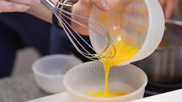 Yemas de huevo batidas con azúcar en un recipiente de vidrio. Golpear las yemas de huevo en un tazón con batidor. Yema de huevo batida — Vídeos de Stock
