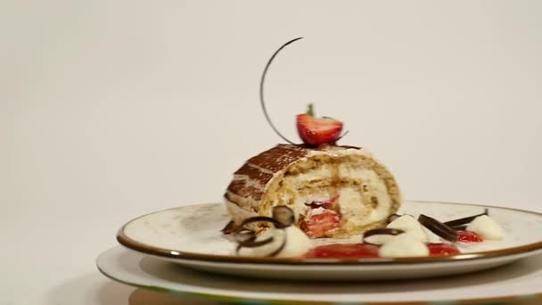 Bovenaanzicht van strawberry cheesecake op houten tafel. Stuk chocolade cake met aardbei versieren bovenop. Een stuk van vochtige cheesecake met een verse aardbei op bovenkant en aardbei — Stockvideo