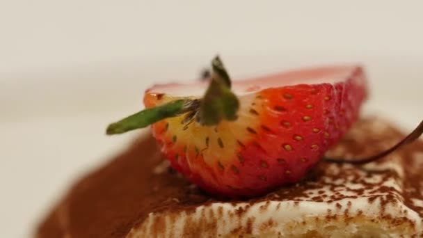 Κομμάτια φράουλας σε άσπρο βανίλιας κρέμα σαντιγί. Εσωτερικη φέτες φράουλας. Εσωτερικη φράουλα κρέπα τούρτα φέτα και σάλτσα στο πιάτο. Μενού επιδορπίων σε καφενείο — Αρχείο Βίντεο
