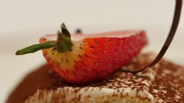 Trozos de fresas en crema de vainilla batida blanca. Las rodajas de fresa se cierran. Cerrar rebanada de pastel de crepe de fresa y salsa en el plato. Menú de postre en la cafetería — Vídeos de Stock