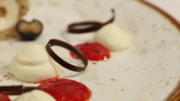 Μαρμελάδα φράουλα σε πλάκα σε άσπρο φόντο. Διακοσμητικά πιάτα — Αρχείο Βίντεο