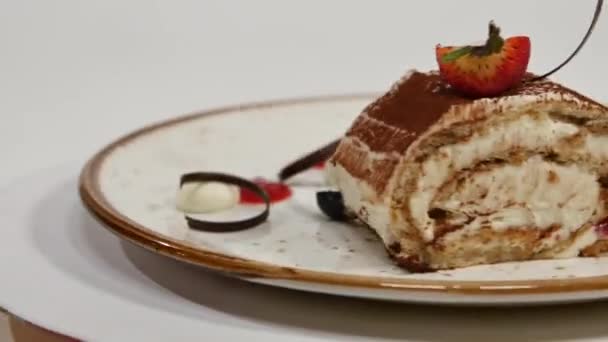 Gâteau aux fraises. Gâteau court aux fraises. Pièce de gâteau au chocolat crémeux sur une assiette en forme de cœur, garnie de fraise en forme de cœur. Gâteau au colza avec garniture aux fraises — Video