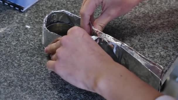 Mänskliga handen håller en rulle av aluminiumfolie. Täck med folie — Stockvideo